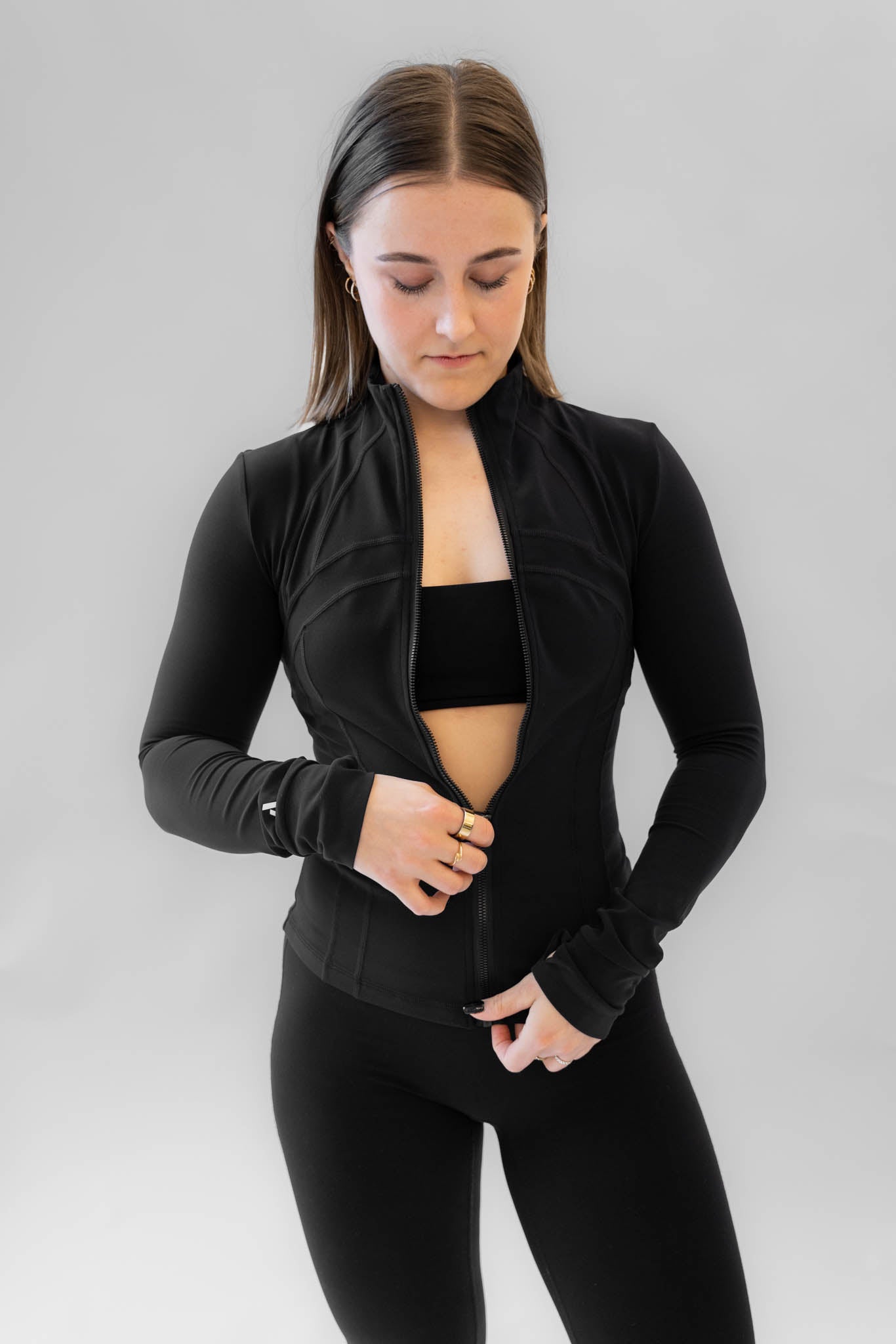Sort SCULPT zip jacket stylet åbent. Matchende activewear sæt.